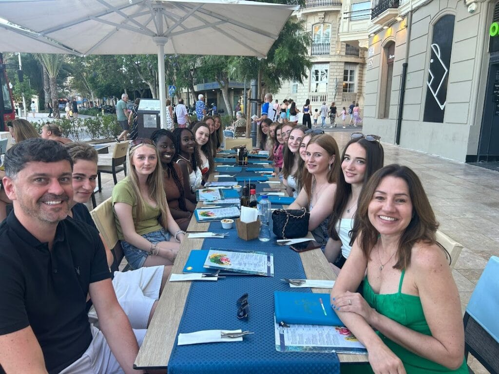 Students and and staff at open-air restaurant. 