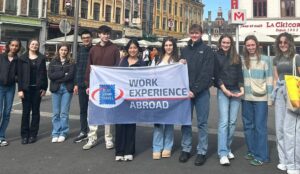 Students holding a Work Experience Abroad flag in Lille.