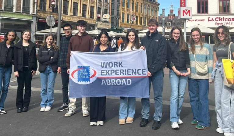 Students holding a Work Experience Abroad flag in Lille.