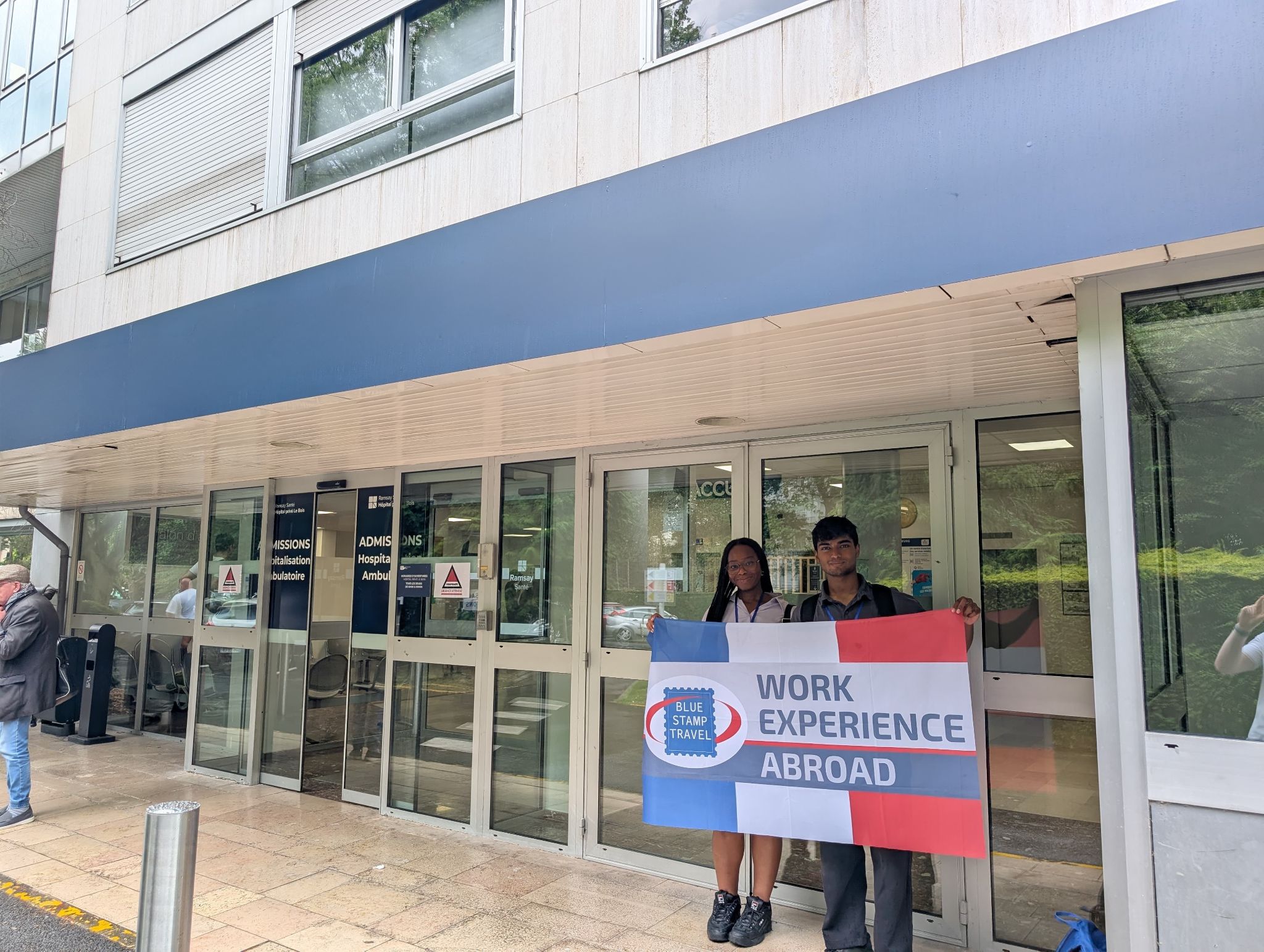 Students holding Work Experience Abroad flag outside their work placement in Lille.