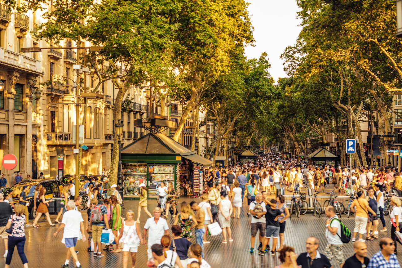 A busy street in Barcelona with tourists and stalls selling souveniers