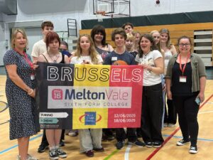 Students on a school trip to Belgium hold up a banner