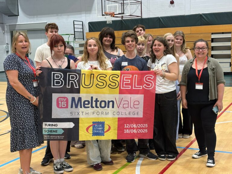 Students on a school trip to Belgium hold up a banner