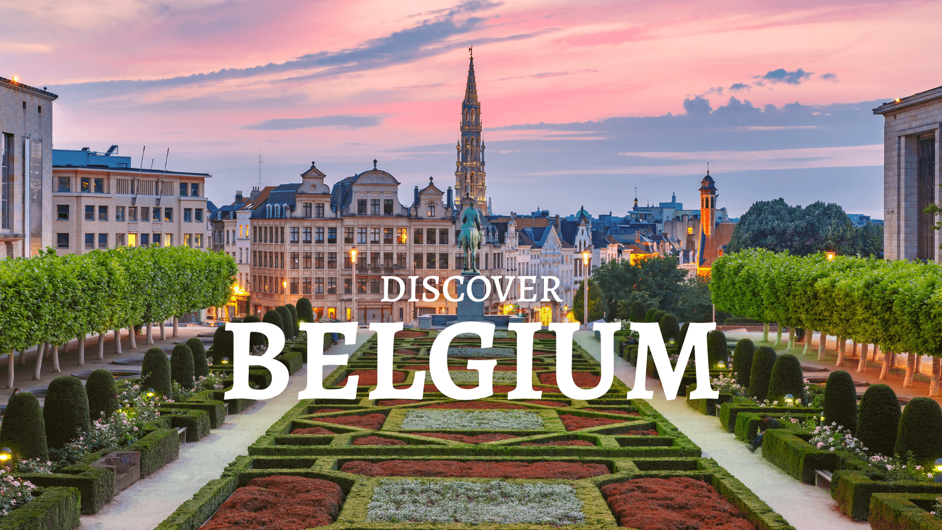 A park in Belgium with bushes, colourful plants and neatly trimmed trees. In the background, historic buildings.