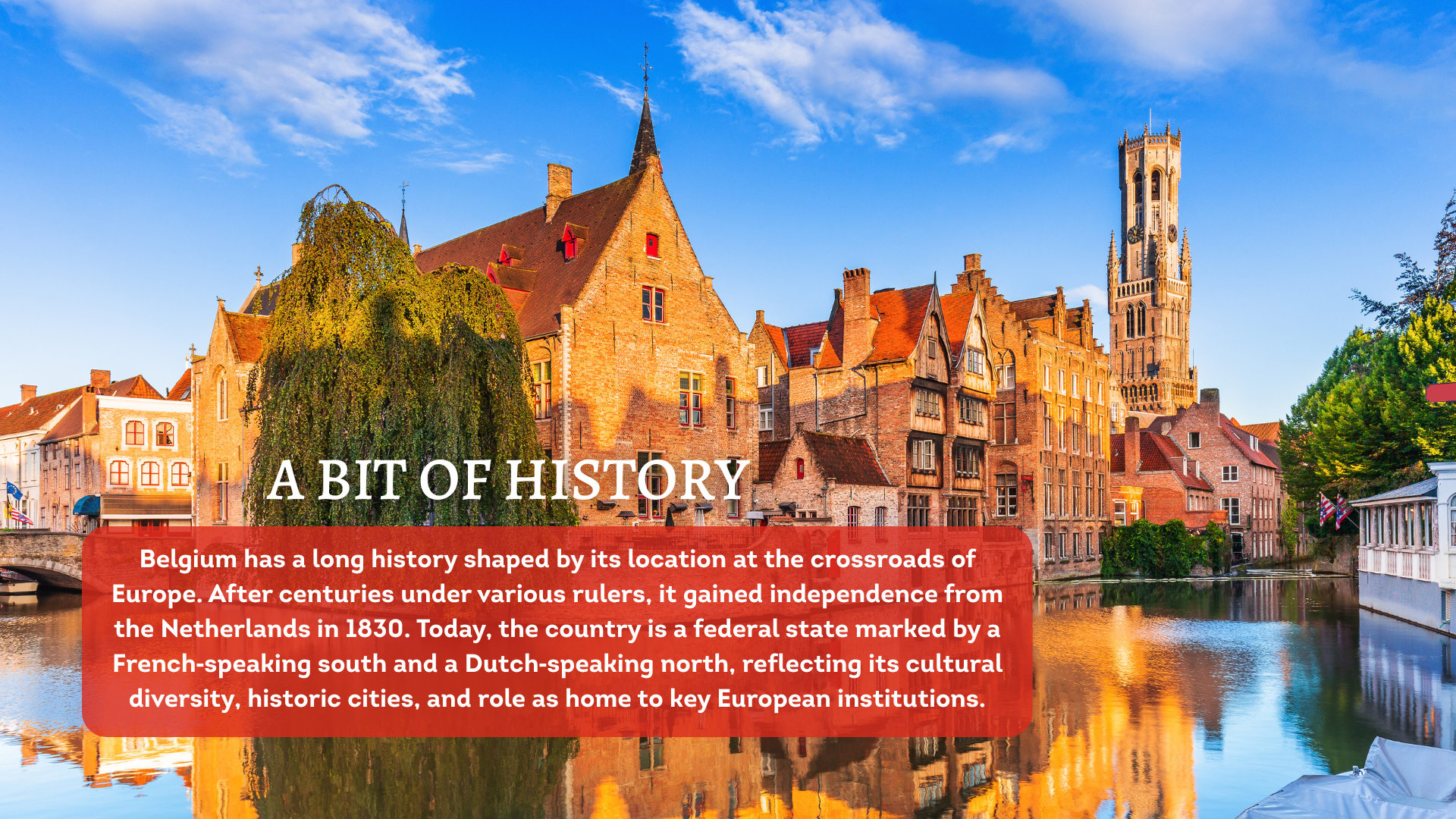 Historic buildings in Bruges lit by the evening sun, with a canal in the foreground.