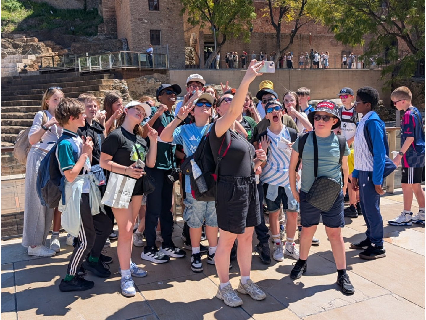 A group of students on a school trip to Malaga pose for a group photo.