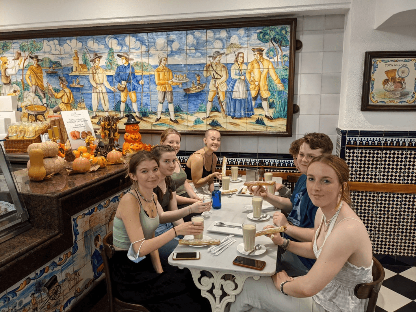 A group of students enjoying horchata and fartons in a brightly-tiled cafe in Valencia