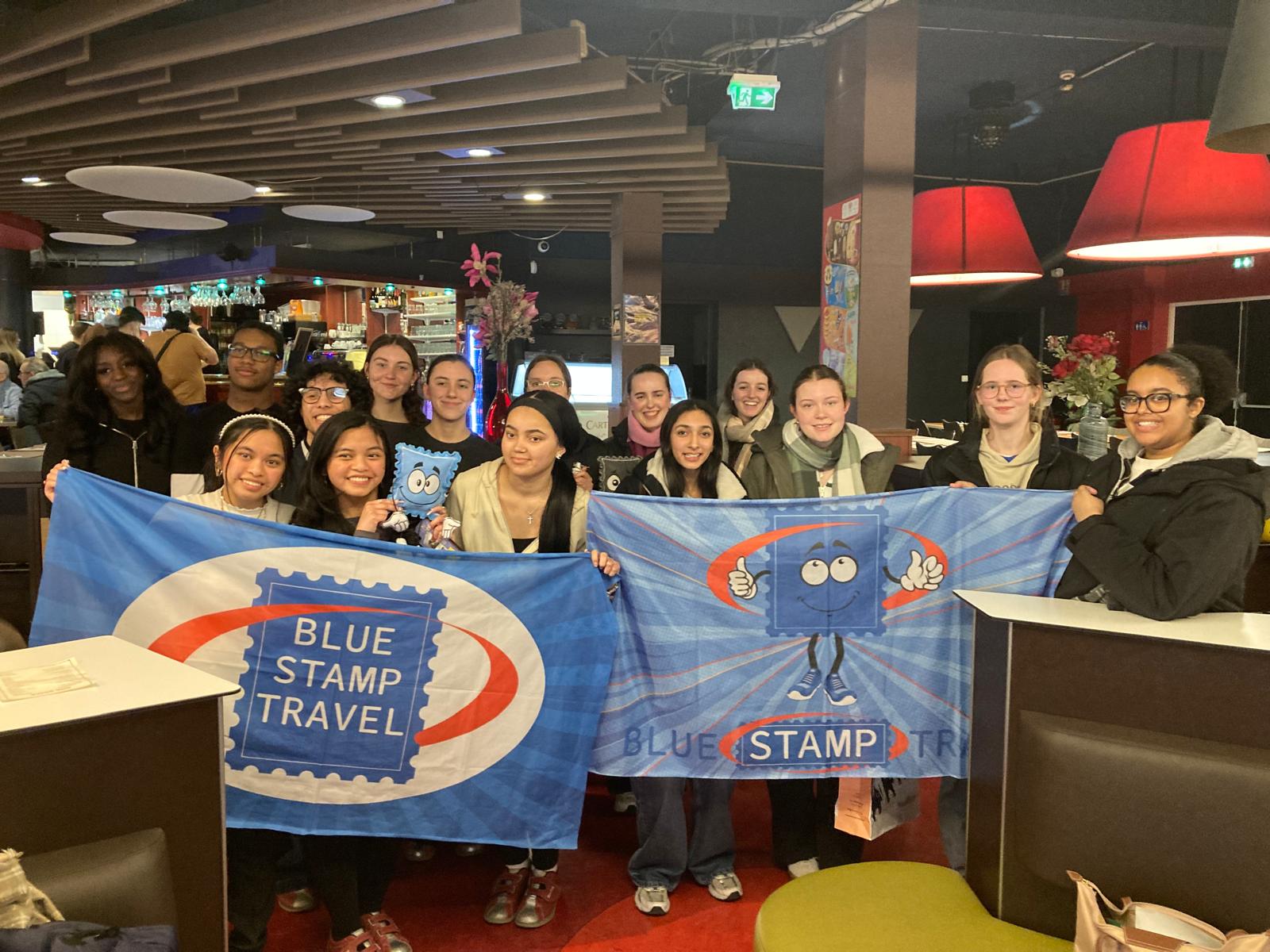 Work Experience students hold Blue Stamp Travel banners in France