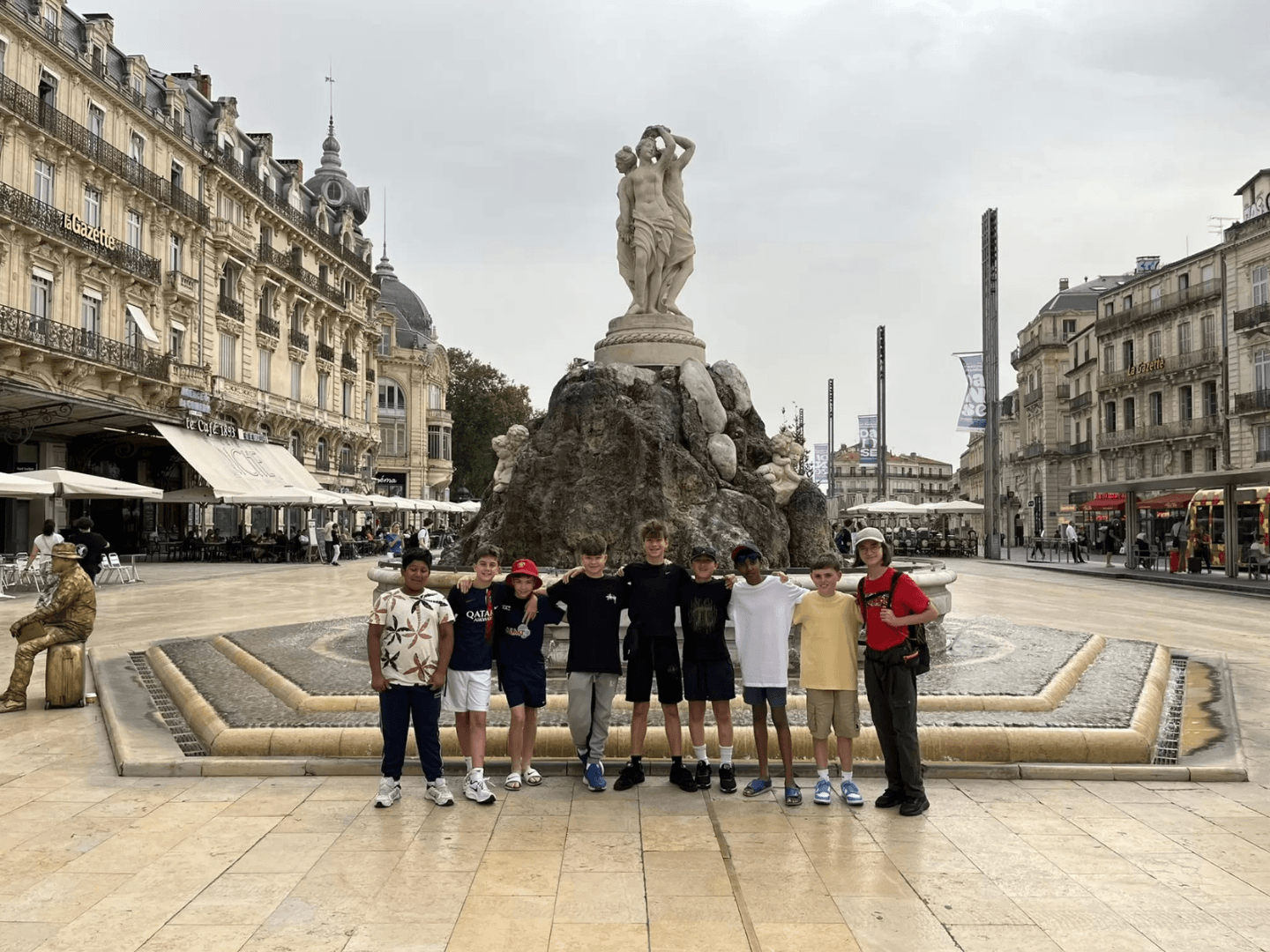 A group of students on a Blue Stamp Travel school trip to Montpellier in front of the fountain on the Place de la Comédie