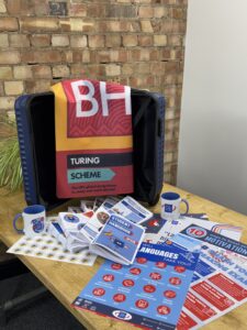 Blue Stamp trip mailing for a teacher with trip guides, promotional material, and Turing Scheme flag.