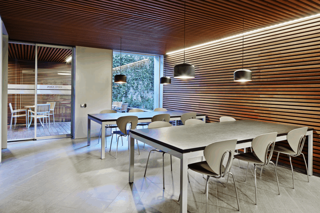 Photo of a warmly lit room with 2 dining tables seating 6 people each.