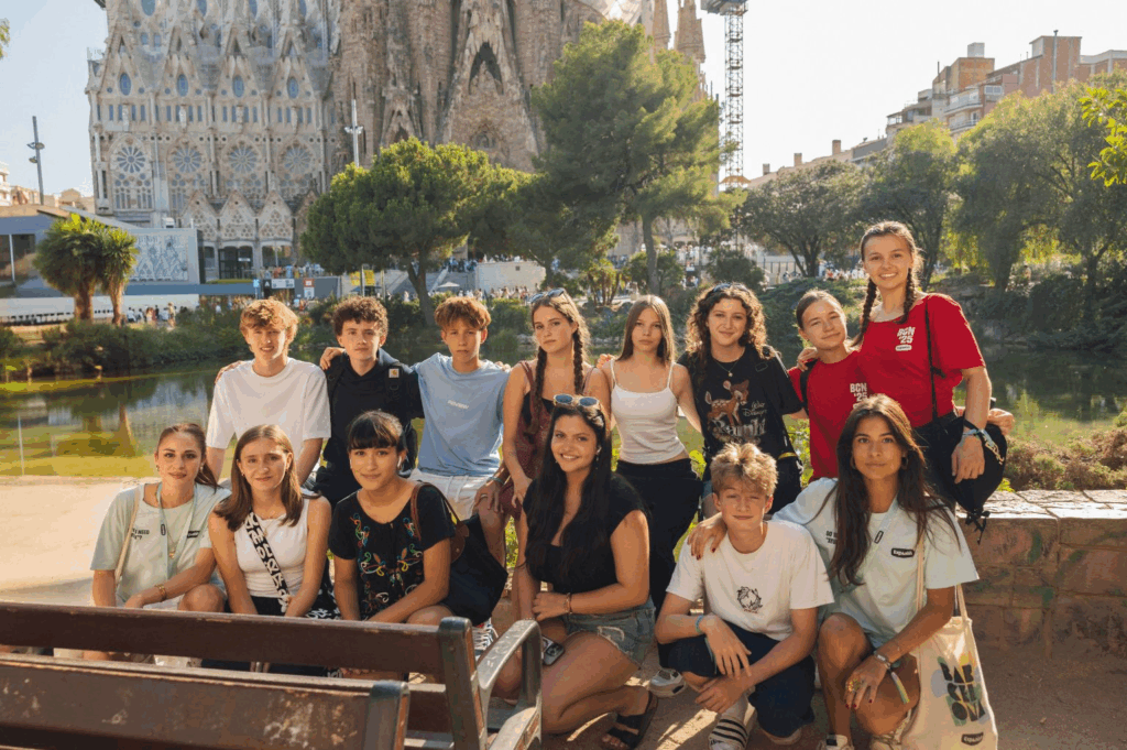 a group of students and staff posed in front of the Sagrada Familia