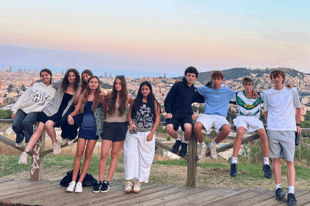 A group of students posed in front of the Barcelona skyline at sunset