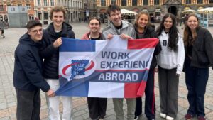 Students holding Work Experience Abroad flag in Lille, Easter 2026.
