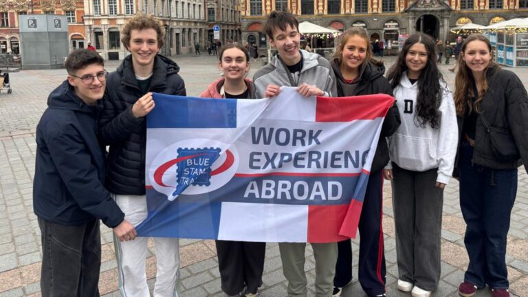 Students holding Work Experience Abroad flag in Lille, Easter 2026.